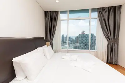 a bedroom with a white bed with a large window at Vortex KLCC by LSA in Kuala Lumpur