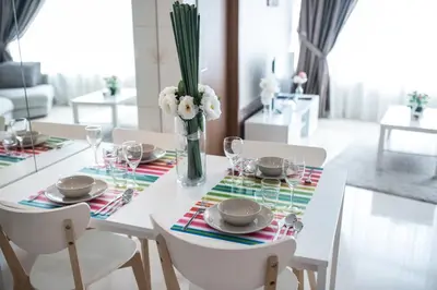 a white dining room table with a vase of flowers at Vortex KLCC by LSA in Kuala Lumpur