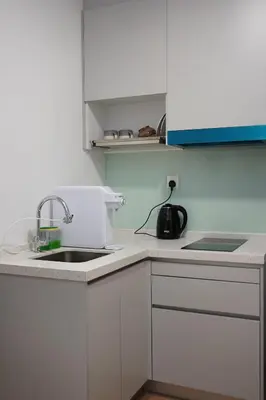 a kitchen with white cabinets and a sink at Riveria City KL Sentral by Nest Suite in Kuala Lumpur