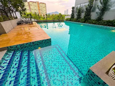 a swimming pool with blue water in a building at Neu Suites by Cozy Homes Near Gleneagles, KLCC & LRT in Kuala Lumpur