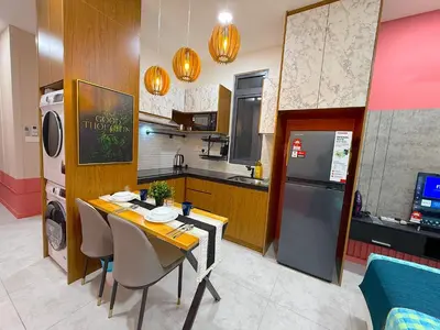 a small kitchen with a table and a refrigerator at Neu Suites by Cozy Homes Near Gleneagles, KLCC & LRT in Kuala Lumpur