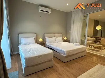 a bedroom with two beds and a living room at KL Tower View Luxury Cozy& Spacious Suite 4-5 Pax in Kuala Lumpur