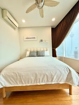 a bedroom with a bed with a ceiling fan at Sky Suites Klcc By Stayner in Kuala Lumpur