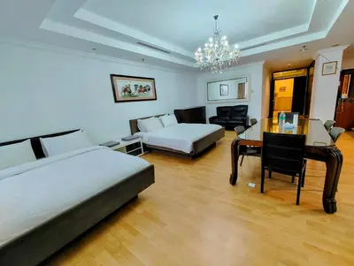 a hotel room with two beds and a table and a desk at Twobedroom Hotel Apartment At Times Square Kuala Lumpur in Kuala Lumpur