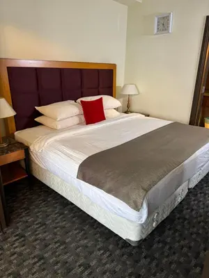 a large bed with a red pillow on top of it at Twobedroom Hotel Apartment At Times Square Kuala Lumpur in Kuala Lumpur