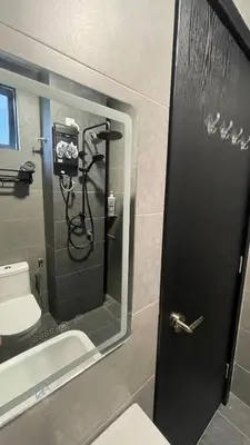 a bathroom with a shower and a toilet and a mirror at Suite16 Kuala Lumpur in Kuala Lumpur