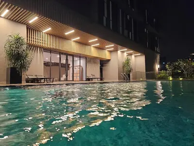 a swimming pool in front of a building at night at Societe Hartamas, Mont Kiara, Kuala Lumpur Golf in Kuala Lumpur