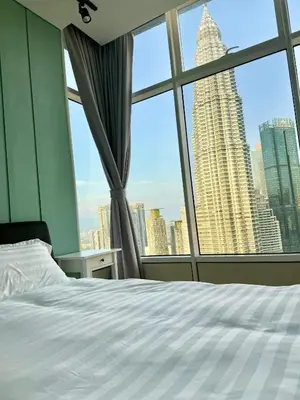 a bedroom with a white bed and a large window at Sky Suites Klcc By Stayner in Kuala Lumpur
