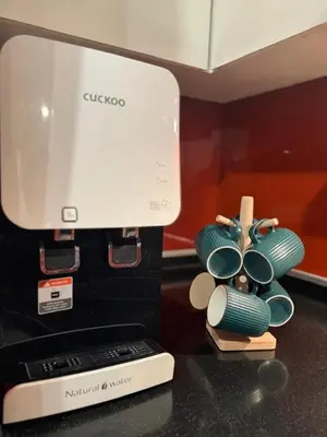 a kitchen counter with a coffee maker and plates on a table at Arcoris Mont Kiara in Kuala Lumpur
