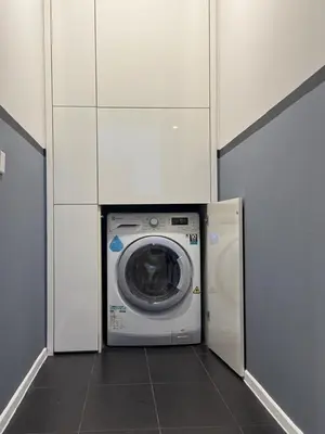 a washing machine in a room with white cabinets at Arcoris Mont Kiara in Kuala Lumpur