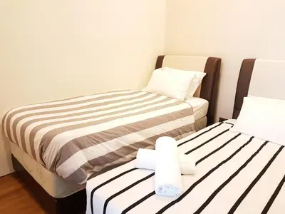two beds in a small room with towels at Soho Suites Pavilion by LSA in Kuala Lumpur