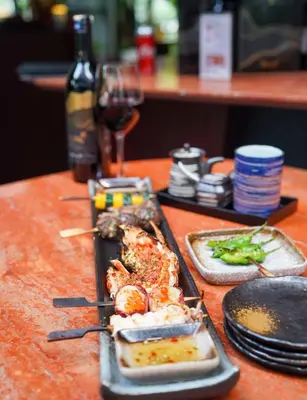 a table with a plate of food and a glass of wine at KL Mont Kiara The Ooak Entire Unit in Kuala Lumpur