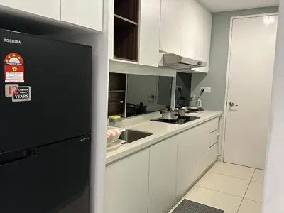 a kitchen with white cabinets and a black refrigerator at The Robertson Bukit Bintang in Kuala Lumpur