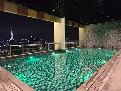 a swimming pool on top of a building at night at MidValley Bangsar Stylish Suite by DingDing in Kuala Lumpur