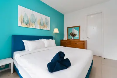 a stuffed blue teddy bear sitting on a bed at Arcoris Soho 163 Mall Luxury 2Bedroom With City View in Kuala Lumpur