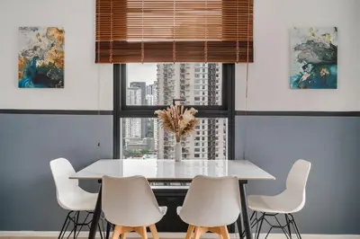 a dining room with a white table and white chairs at Arcoris Soho 163 Mall Luxury 2Bedroom With City View in Kuala Lumpur