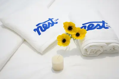 a bag of towels with yellow flowers and a candle at Riveria City Kuala Lumpur in Kuala Lumpur
