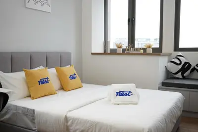 a white couch with yellow and blue pillows on it at Riveria City Kuala Lumpur in Kuala Lumpur
