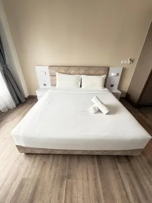 a large white bed in a room with wooden floors at Agile Delima Luxury suite Bukit Bintang in Kuala Lumpur
