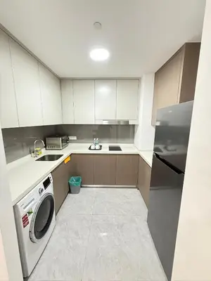 a kitchen with white cabinets and a washer at Agile Delima Luxury suite Bukit Bintang in Kuala Lumpur