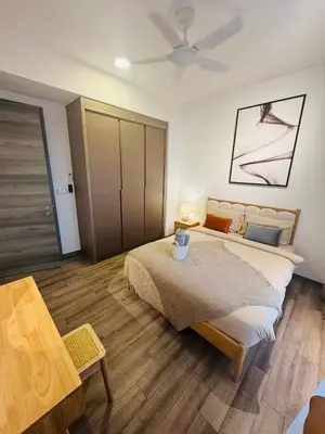 a bedroom with a large bed and a table at Agile Delima Luxury suite Bukit Bintang in Kuala Lumpur