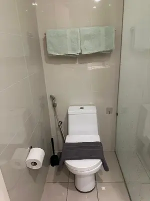 a bathroom with a white toilet with a towel on it at MCity Studio With Balcony, Near KLCC, Gleneagles Hosp, Ampang Puteri Hosp in Kuala Lumpur