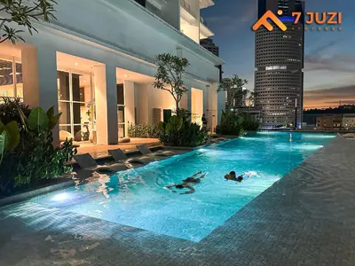 a large swimming pool with chairs and a building at 2BED Luxury Cozy Suite 118TOWER view with NetflixHD1080 in Kuala Lumpur