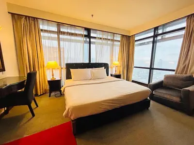 a bedroom with a bed and a desk and a chair at TIMES SQUARE SERVICE SUITE at KUALALUMPUR in Kuala Lumpur