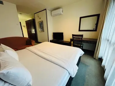 a hotel room with a bed and a chair at TIMES SQUARE SERVICE SUITE at KUALALUMPUR in Kuala Lumpur