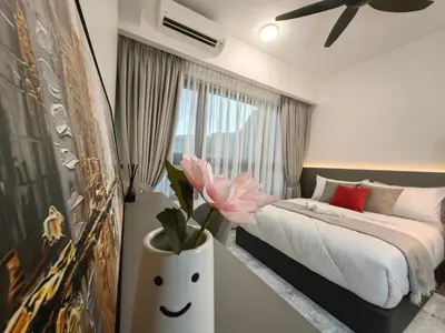 a bedroom with a bed and a vase with a flower at TRX Agile Bukit Bintang 2 Bedroom Deluxe Suites in Kuala Lumpur