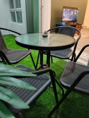 a table and chairs in a room with green grass at Modern and Comforts RC Residence Fully Aircond in Kuala Lumpur