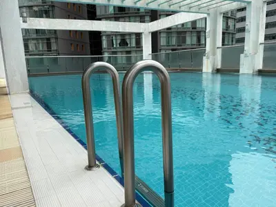 a swimming pool in a building with blue water at Park view Apartment near klcc in Kuala Lumpur