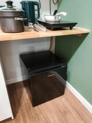 a black dishwasher under a wooden shelf in a kitchen at Studio Sunway Velocity 2 Link Bridge to Mall in Kuala Lumpur