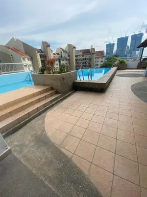 a swimming pool with a bench and stairs and buildings at Studio apartment in Kuala Lumpur