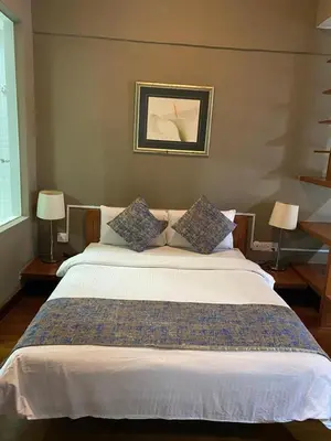 a large bed in a bedroom with two lamps at Studio apartment in Kuala Lumpur