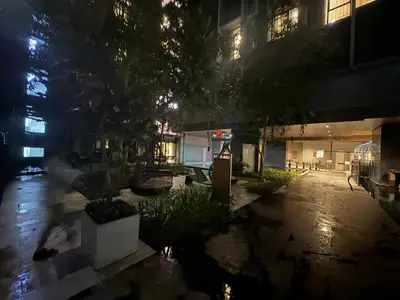 a person walking in front of a building at night at Expressionz KLCC By Laze Home in Kuala Lumpur