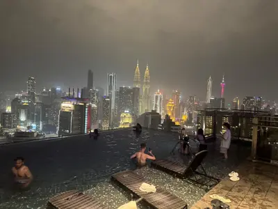 a group of people sitting on the edge of a building at Expressionz KLCC By Laze Home in Kuala Lumpur