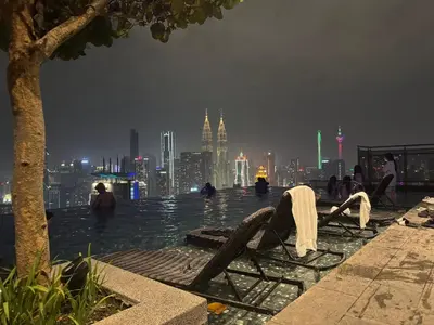 a pool with a view of a city at night at Expressionz KLCC By Laze Home in Kuala Lumpur