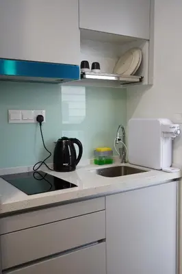a white kitchen with a sink and a stove at Riveria City Kuala Lumpur By Nest Suites in Kuala Lumpur