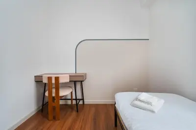 a bedroom with a bed and a desk with a chair at Sydney Sunset 3BR M Vertica Near MRT by RumaBnB in Kuala Lumpur
