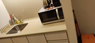 a kitchen counter with a microwave and a sink at Parkview Family Suite klcc with views in Kuala Lumpur
