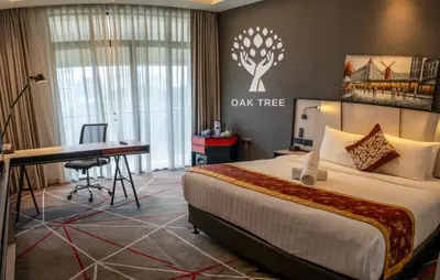 a hotel room with a bed and a desk and a laptop at The Oak Room At M101 in Kuala Lumpur