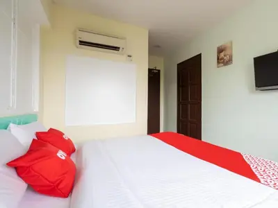 a bedroom with a white bed with red pillows at OYO 89717 Budget Star Hotel in Kuala Lumpur