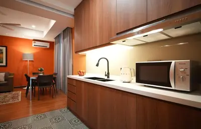 a kitchen with a sink and a microwave at Acappella Kuala Lumpur City Centre in Kuala Lumpur