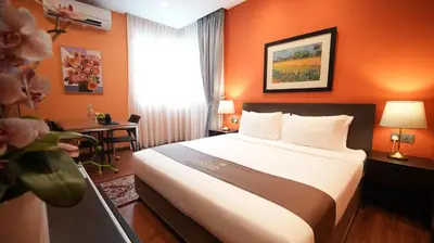 a hotel room with a large bed and a desk at Acappella Kuala Lumpur City Centre in Kuala Lumpur