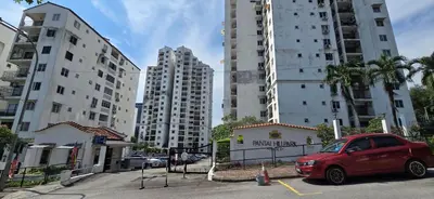 a red car parked in a parking lot with tall buildings at Pantai Hillpark phase 5 in Kuala Lumpur