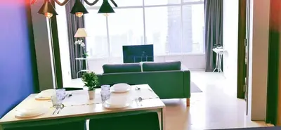 a living room with a green couch and a table at Vortex KLCC by Family Suites in Kuala Lumpur