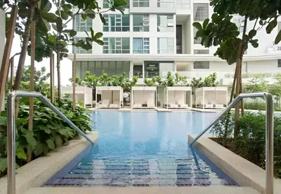 a swimming pool with lounge chairs in front of a building at The Robertson by Kuala Lumpur in Kuala Lumpur