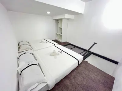 two beds in a room with white walls at Seeds Hotel Premier Chow Kit Kuala Lumpur in Kuala Lumpur
