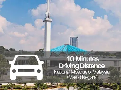 a city with a white minibus driving in front of a monument at Seeds Hotel Premier Chow Kit Kuala Lumpur in Kuala Lumpur